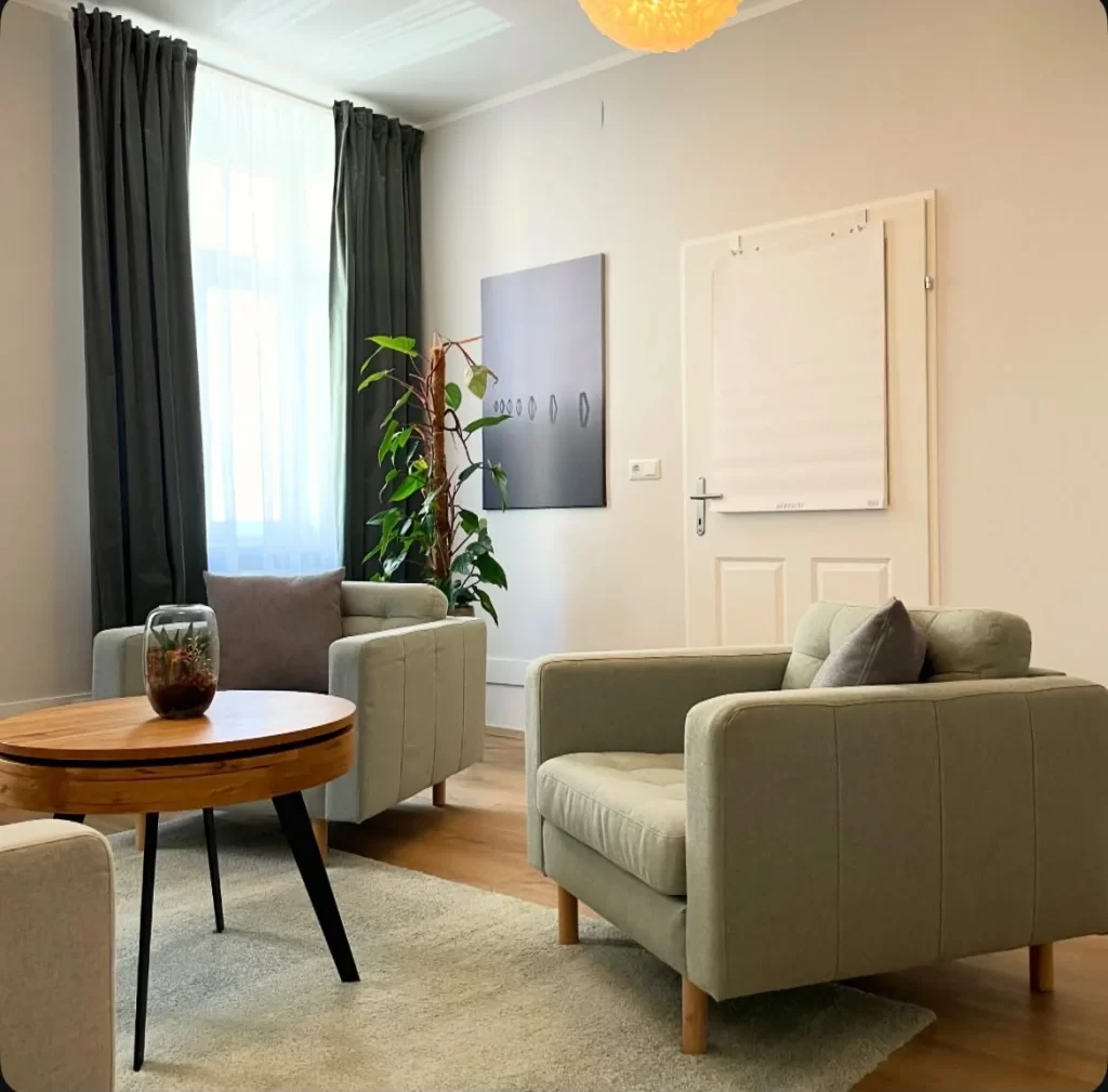 Sitzecke mit salbeigrünen Sesseln und Zimmerpflanze